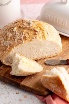 a loaf of bread sitting on top of a wooden cutting board next to a knife