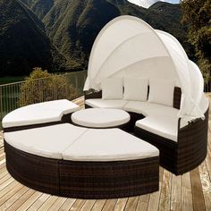 an outdoor day bed on a deck with mountains in the background