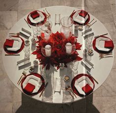 the table is set with red and white place settings