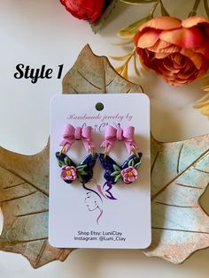 two small bows are attached to the back of ear clips with pink flowers on them