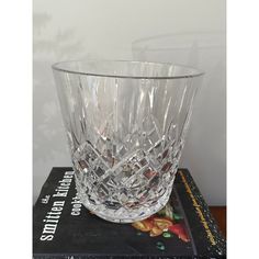 a clear glass vase sitting on top of a book