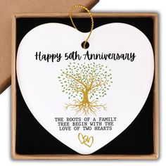 a white heart shaped ornament with a tree on it and the words, happy 50th anniversary