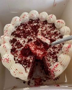 a cake with white frosting and red sprinkles