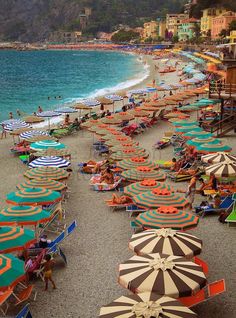 the beach is crowded with people and umbrellas