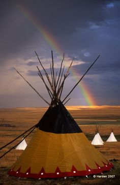 a teepee with a rainbow in the background