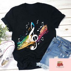 Product details: ✔️ NAME: Colorful Music Note Teacher T-Shirt, Music Note Shirt, Music Teacher Shirt, Cute Teacher Shirt, Musical Notes Tee ✔️ IMPORTANT NOTE: Both Men and Women can we our shirts because this is unisex style t-shirts;  Wash item inside out in cold water, do not bleach, do not dry clean, do not iron directly on the design. ✔️ MATERIAL: 5.3-ounce, 100% cotton (99/1 cotton/poly (Ash) & 90/10 cotton/poly (Sport Grey); Heavyweight classic unisex tee; Taped neck and shoulders; Tearaway label; Decoration type: Digital Print ✔️ OUR DESIGN PRODUCTS: Each One are designed and sold in limited quantities. The designs are created by our incredibly talented in house graphic art team who often hand draw and illustrate each Tee shirt design. ✔️ SIZE CHART: Please refer the attached size c Multicolor Cotton T-shirt For Music Festival, Summer Music-themed Tops With Graphic Design, Summer Music-themed Graphic Tops, Music-themed Letter Print T-shirt For Concert, Black Music-themed T-shirt With Letter Print, Music-themed Cotton T-shirt With Graphic Design, Summer Music-themed T-shirt For Concerts, Black Music-themed T-shirt With Sublimation Print, Music-themed T-shirt For Summer Concerts