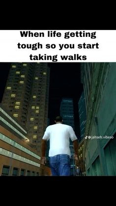 a man walking down a city street at night with the words, when life getting tough so you start taking walks