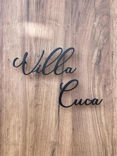 the word villa cuca written in wrought iron on a wooden surface with an arrow pointing to it