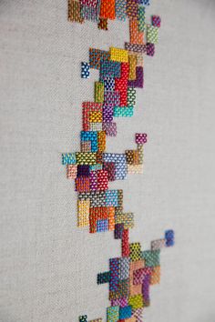 a close up of a cross stitch pattern on a wall