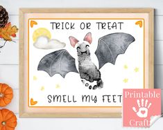 a halloween sign with a bat and handprint on it, next to some pumpkins