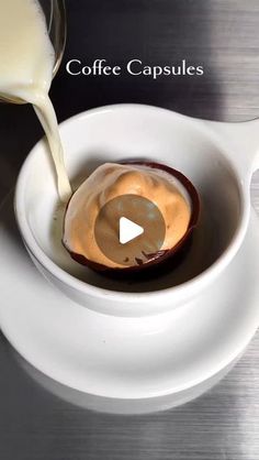 a spoon pouring milk into a bowl filled with coffee cappuccinos on top of a white saucer