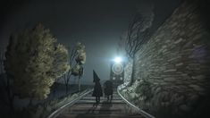 two people are walking down the railroad tracks at night