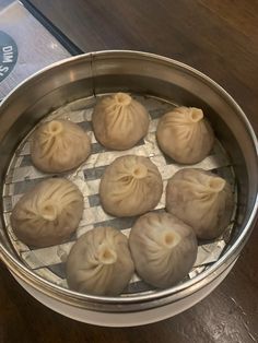 some dumplings are sitting in a metal pan on a wooden table and it is ready to be cooked