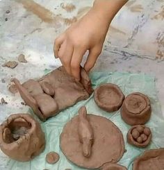 a person is making clay sculptures on a table