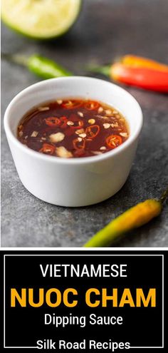 vietnamese nuoc cham dipping sauce in a white bowl with limes and chili