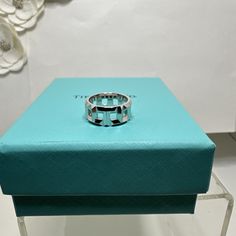 This exquisite 18k white gold ring from Tiffany & Co. is a timeless piece that is perfect for any occasion. The ring features an 8mm band width and is a size 5. It is a part of the Tiffany True collection, which is a symbol of true love, and is made in Italy. The ring is signed by Tiffany & Co. and is crafted with the finest materials, including high-quality gold. It does not feature any diamonds or gemstones, making it perfect for those who prefer a simpler yet elegant design. This ring is suitable for engagement, wedding, anniversary, graduation, Christening, and other special occasions. Has minor scratches Designer White Rings For Gifts, Classic White Aaa Quality Rings, Designer Hallmarked White Gold Rings, Designer White Gold Rings Hallmarked, Designer White Gold Hallmarked Rings, Designer Silver Platinum Rings, Designer White Gold Ring In Sterling Silver, Designer White Gold Promise Ring, Luxury Wide Open Band Ring With Polished Finish