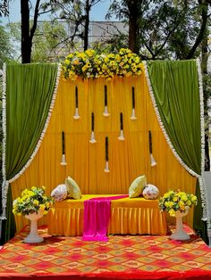 a decorated stage with yellow drapes and flowers