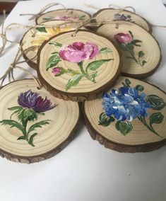 four pieces of wood with painted flowers on them sitting on top of a white table