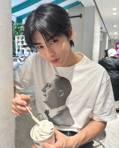 a young man holding a bowl of ice cream