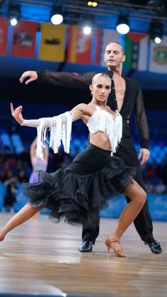 two dancers in black and white outfits on a dance floor