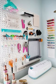 a pegboard with scissors and other crafting supplies hanging on it's wall