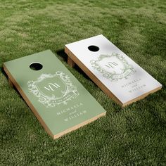 two personalized cornhole game boards sitting on the grass in front of each other