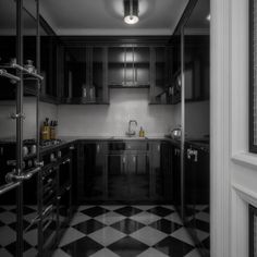 a black and white kitchen with checkered flooring on the walls, cabinets, stove top ovens and sink