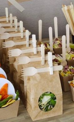 there are many paper bags with forks sticking out of them and vegetables in each bag