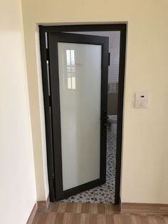 an open door leading to a bathroom with tiled flooring and walls in the background