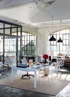 an office with lots of windows and furniture