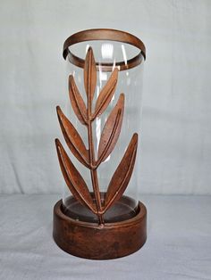 a wooden and glass vase sitting on top of a table