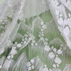 This exquisite Beaded 3D Floral Lace Fabric Embroidered on 100% Polyester Net Mesh is the perfect choice for creating unique, couture-level designs. Soft yet durable, this high quality fabric is beautifully crafted, adding texture and texture and dimension to your creations. From wedding dresses and bridal gowns to special occasion wear and dancewear, this fabric will make any design stand out. With its beading, pearls, and sequined accents, it will provide the perfect finishing touch. Shopping White Embroidered Party Fabric, Party Embroidered White Fabric, White Embroidered Fitted Fabric, Embroidered White Tulle Fabric For Party, Embroidered White Lace For Spring, Elegant White Fabric For Spring, White Lace Fabric For Party, White Embroidered Fabric With Appliques For Party, Elegant White Embroidered Fabric With 3d Embroidery