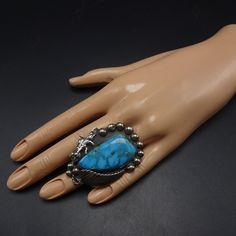 "VINTAGE NAVAJO RING DESCRIPTION: This impressive ring features a huge specimen of high blue turquoise with wispy matrix and quartz inclusions. The gemstone is secure in smooth bezel, on a foundation of heavy gauge vintage sterling silver. Applied leaf and plump raindrops frame the impressive turquoise cabochon. This ring will be a treasured addition to your collection of fine vintage Native American jewelry. MEASUREMENTS: Ring face measures 2\" x 1 1/2\" Cabochon measures 37mm x 19mm RING SIZE: Collectible Untreated Blue Turquoise Ring, Bohemian Blue Collectible Ring, Jewelry Measurements, Turquoise Men, Vintage Native American Jewelry, Navajo Rings, Vintage Navajo, Rings Cool, Coral Turquoise