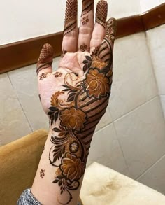 a woman's hand with hennap and flowers on it, showing the intricate design