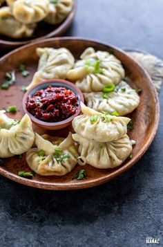 dumplings on a plate with dipping sauce