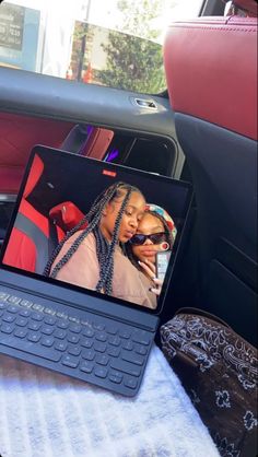 a laptop computer sitting on top of a table in the back seat of a car