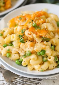 a white plate topped with pasta and peas