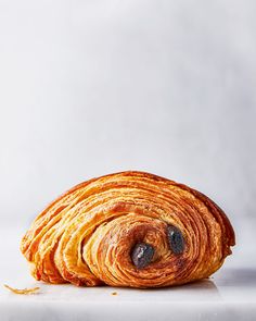 an orange croissant on a white surface