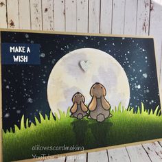 a handmade card with two dogs sitting on the grass under a full moon and words make a wish