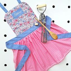 an apron and utensils are sitting on top of a polka dot tablecloth