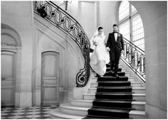 a bride and groom are walking down the stairs at their wedding reception in black and white