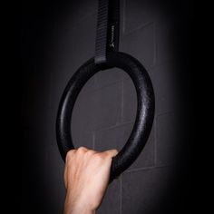 a person is holding up a black ring