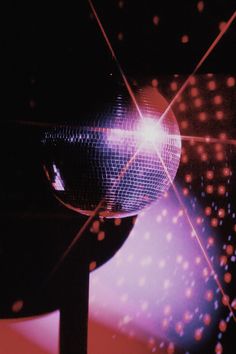 a disco ball is shown in the middle of an image with bright lights around it