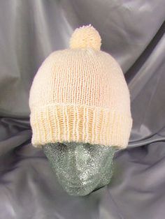 a white knitted hat sitting on top of a mannequin head