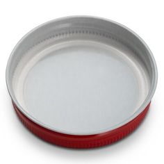 a red and silver plate on a white background with clippings to the bottom