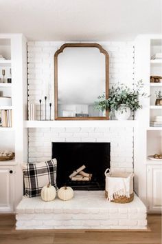 a living room with a fireplace, mirror and other items on the mantle in front of it