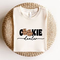 Cookie Dealer ShirtCookie ShirtBaking GiftBaking ShirtFunny Baker ShirtCookie Lover ShirtCookie GiftCookie Lover GiftBaker GiftCookieGift For BakerGift For HerGift For Him ✔️✔️How to order✔️✔️ 1️⃣ Select the size of tshirt you want from the drop-down 2️⃣ Select the color of tshirt you want from the drop-down 3️⃣ Go for last image of listing and select Lettering Color from Lettering Color Chart and then write your selection in to the Personalization Box. 🌟If you want to buy more products, go bac Cookie T Shirt Design, Bakery Tshirt Ideas, Cookie Apron Ideas, Baker Shirt Ideas, Cookie Tshirt Design, Cookie Shirts Ideas, Bakery Clothes, Baking Shirts Design, Bakery Shirts