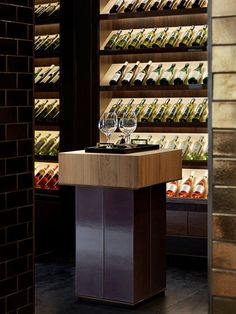 an empty wine glass is sitting on a table in front of shelves with bottles and glasses