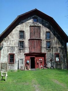 an old barn with two chairs in front of it