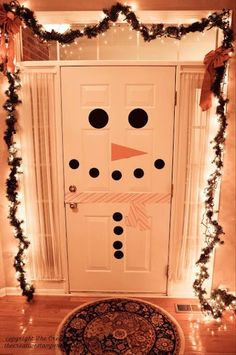 a snowman door decorated with christmas lights and garland on the front entrance to a house